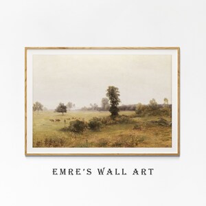 May include: A framed painting depicting a rural landscape with a group of cattle grazing in a field. The painting features a hazy sky, green trees, and a grassy field.