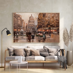 May include: A framed oil painting depicts a bustling Parisian street scene. The artwork features a large domed building, figures, and a flower cart. The color palette is dominated by warm browns, tans, and touches of blue, creating a vintage aesthetic.