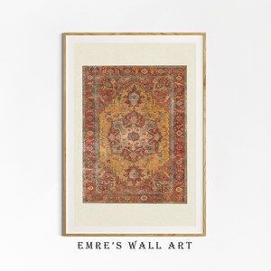 May include: A framed print of a vintage rug with a red, orange, and green geometric pattern. The rug has a central medallion with a floral design. The frame is a light wood colour.