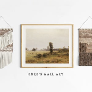 May include: Three wall decor pieces, including a framed landscape painting of a field with a tree in the distance, and two woven wall hangings with fringe. The wall hangings are in shades of brown and white.