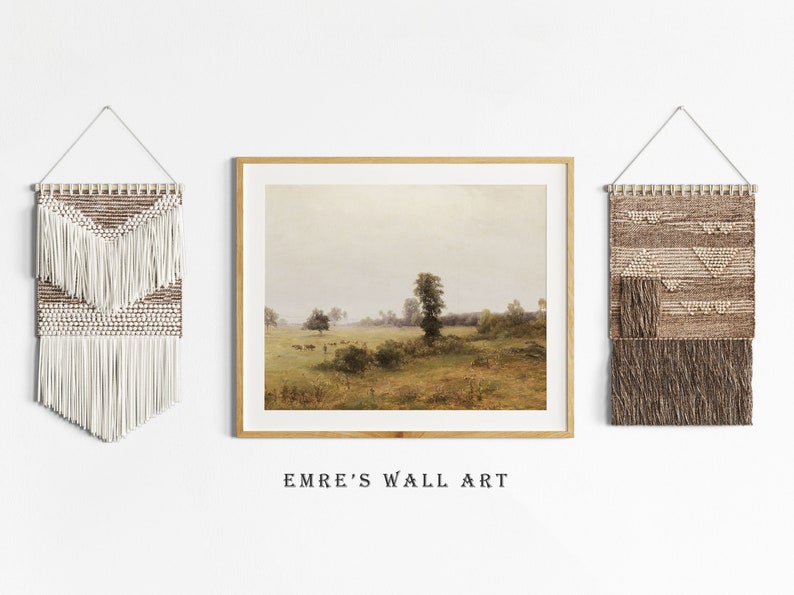 May include: Three wall decor pieces, including a framed landscape painting of a field with a tree in the distance, and two woven wall hangings with fringe. The wall hangings are in shades of brown and white.