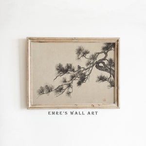 May include: A framed print with a monochrome illustration of a pine tree branch. The artwork is set against a beige background and is enclosed in a light brown wooden frame. The text "EMRE'S WALL ART" is printed at the bottom.