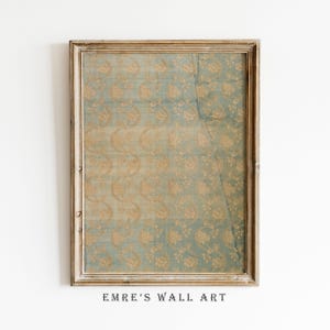 May include: Framed wall art featuring a vintage-style floral pattern in shades of blue and gold. The artwork is enclosed in a distressed, light-colored wooden frame. The text "EMRE'S WALL ART" is printed at the bottom.