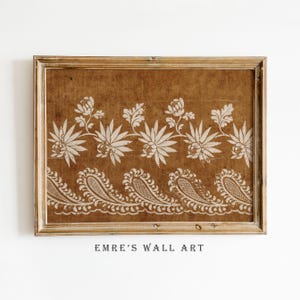 May include: A framed print featuring a brown background with a white floral and paisley design. The artwork is in a wooden frame and includes the text "EMRE'S WALL ART" at the bottom.
