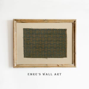 May include: A framed textile artwork. The piece features a section of patterned fabric in teal and gold hues, mounted on a neutral background within a gold-toned wooden frame. The text "EMRE'S WALL ART" is printed at the bottom.