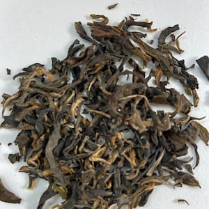 May include: Loose leaf black tea with brown and green leaves.