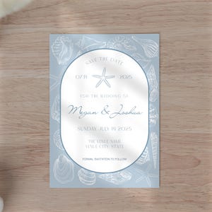May include: A light blue save the date card with a white oval in the center. The oval contains the text "Save the Date", "07 14 2025", "For the Wedding of Megan & Joshua", "Sunday July 14 2025", "The Venue Name", "Venue City State", and "Formal Invitation to Follow". The card is decorated with a white starfish and white drawings of seashells.