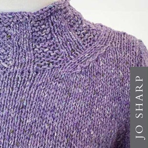 Peut inclure: Gros plan sur un pull en maille de couleur violette avec un col montant et un motif de point texturé. Le pull est réalisé avec un fil chiné qui présente une subtile variation de couleur. Le texte "JO SHARP DIGITAL PATTERN" est visible dans le coin inférieur droit de l'image.