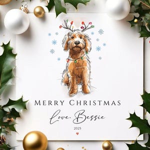 Peut inclure: Carte de Noël avec un dessin d'un chien brun orné de guirlandes lumineuses et de bois de renne. La carte affiche "Merry Christmas, Love Bessie, 2025" en écriture cursive. Le design est encadré de feuilles de houx et de boules dorées.