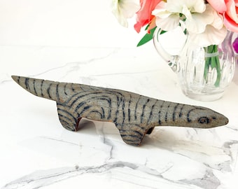 Figura de lagarto de madera tallada al estilo folclórico, con estampado llamativo y estilo vintage.