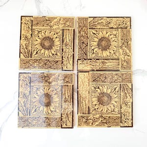 May include: A set of four square ceramic tiles featuring a relief design of sunflowers and various floral patterns. Each tile has a cream and dark brown color palette with a distinct crackle glaze finish, showcasing intricate botanical details.