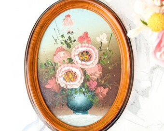 Cuadro al óleo floral ovalado vintage con marco, flores rosas, jarrón azul y técnica impasto.