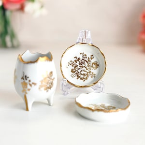 Juego de tocador de porcelana francesa B.B. con platitos decorativos dorados con diseño floral, estilo vintage.