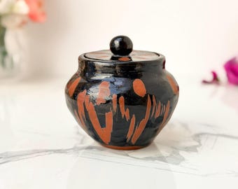 Olla con tapa de cerámica del estudio David Knee, esmalte negro y naranja, 1968.