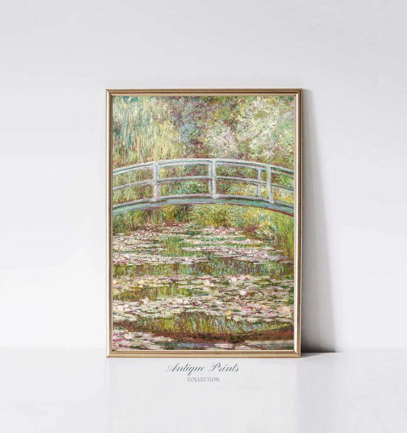 May include: A framed painting of a white bridge over a pond with water lilies. The bridge is painted in a light blue color and the water lilies are painted in shades of green, white, and pink. The painting is set against a background of trees and foliage.
