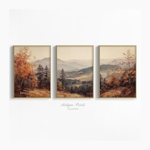 May include: Set of three framed landscape art prints. Each print features a watercolor painting of a mountain scene with trees in shades of brown, orange, and green. The frames are gold-colored. The text "Antique Prints Collection" is at the bottom.
