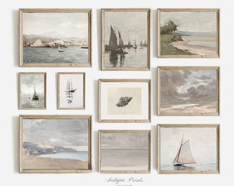May include: A gallery wall of nine framed antique prints featuring seascapes, sailboats, and a seashell. The prints are in muted tones of blue, gray, and white, and have a vintage aesthetic. The frames are a light wood color.
