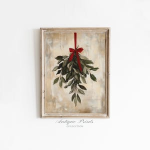 Puede incluir: Pintura enmarcada de una rama de muérdago con una cinta y un lazo rojos. Las hojas son verdes y el fondo tiene un aspecto neutro y texturizado. El texto "Antique Prints Collection" está en la parte inferior.