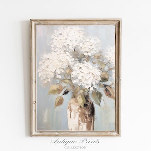 Pode incluir: Impressão emoldurada em estilo antigo, apresentando uma natureza morta de hortênsias brancas em um vaso marrom. A pintura utiliza uma técnica impressionista com um acabamento texturizado, em um fundo azul e verde suave. As palavras "Antique Prints Collection" estão na parte inferior.