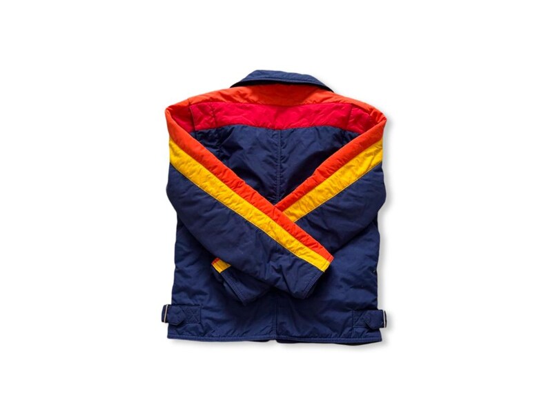 May include: A vintage blue jacket with red and orange accents on the shoulders and collar. The sleeves feature yellow and orange stripes. The jacket has a collared neckline and two adjustable waist straps.