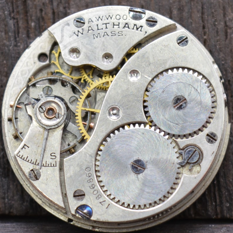May include: Close-up of a silver pocket watch movement with the inscription "A.W.W.CO. WALTHAM, MASS." and the serial number "1780890".