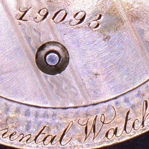 May include: Close-up of a silver watch back with the inscription "Continental Watch Co." and the number "19093".