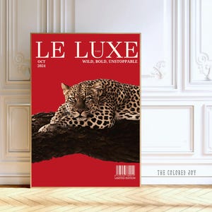 May include: A framed art print featuring a leopard resting on a tree branch against a red background. The text "LE LUXE PARIS" is at the top, with "OCT 2024" below. The words "WILD, BOLD, UNSTOPPABLE" are also displayed.