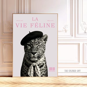 May include: Black and white art print featuring a leopard wearing a black beret and a polka dot scarf. The print has the text "LA VIE FÉLINE" in pink, with a barcode and the text "THE COLORED JOY".