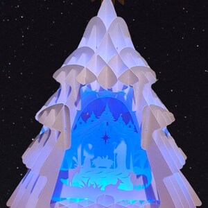 Christmas paper lamp in the shape of a Christmas tree with a nativity scene and LED lights.