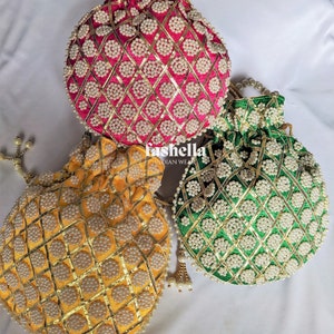 Peut inclure: Trois pochettes rondes en perles avec des broderies dorées. Les pochettes sont rose, verte et jaune. Chaque pochette a une fermeture à cordon et un pompon en perles.