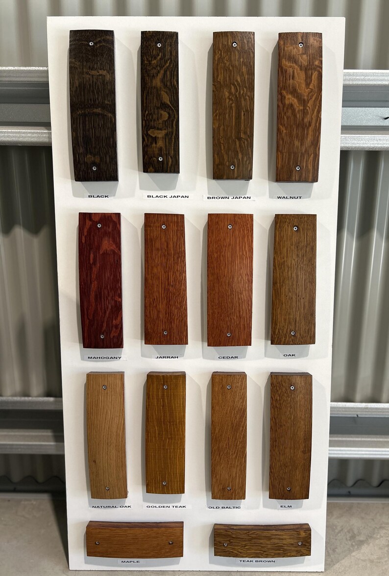 K&ouml;nnte beinhalten: Eine Holzbeizfarbkarte mit 12 verschiedenen Holzbeizfarben. Die Farben sind mit ihren Namen beschriftet: Schwarz, Schwarz Japan, Braun Japan, Nussbaum, Mahagoni, Jarrah, Zeder, Eiche, Natur Eiche, Goldener Teak, Altbaltisch, Ulme, Ahorn und Teakbraun.