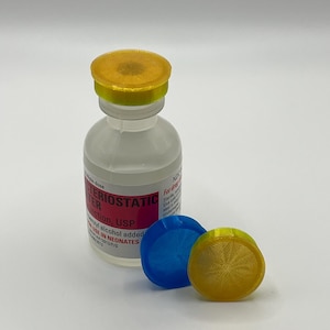 May include: A clear glass vial with a yellow and gold cap, labeled "Bacteriostatic Water for Injection, USP." Two blue and yellow caps are next to the vial. The vial contains a clear liquid.