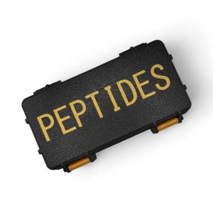 May include: A black rectangular case with the word "PEPTIDES" in gold lettering. The case has a textured surface and gold-colored handles. The case is closed and appears to be made of a durable material.