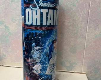 Op de afbeelding: Een blauwe en witte roestvrijstalen beker met een baseball-thema met een baseballspeler in een blauw en wit uniform met het woord "Shohei Ohtani" op de beker.