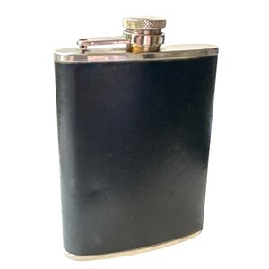 May include: A black leather-covered flask with a silver top and a silver rim around the opening.