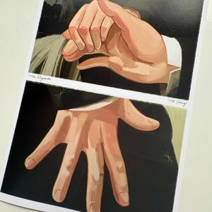 May include: Two art prints depicting illustrations of hands. One shows clasped hands, the other an open hand. The prints have text that reads "Miss Elizabeth" and "Mr. Darcy". The prints are on white paper.