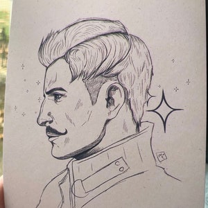 May include: A black and white line drawing of a man's profile with a mustache. He has a short, styled haircut and is wearing a jacket with a buttoned collar. The drawing is on a light brown background with a small star in the upper right corner.