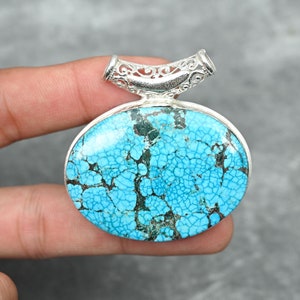 May include: A turquoise pendant with a silver filigree bail. The turquoise is a bright blue with a spiderweb pattern.