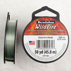 Może przedstawiać: Dwie szpule zielonej nici do tkania koralików WildFire, zgrzewanej termicznie. Jedna szpula jest na boku, odsłaniając nić. Druga szpula ma etykietę z napisem "WildFire" i "50 yd (45,8 m)".