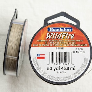 以下が含まれることがあります： ベージュ色のWildFire熱接着ビーズ織り糸の2つのスプール。ラベルには、0.15mmの糸が45.8メートルと記載されています。パッケージには、Beadalonのブランド名とアメリカ国旗が含まれています。