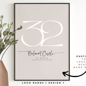 May include: A printable wall art design featuring the number 32 in a white cursive font on a light beige background. The text "Belmont Circle" is written in black cursive font below the number. The text "MR & MRS SMITH" and coordinates are written in black font below the address. The text "LOCO RANGE | DESIGN 7" is written in black font at the bottom of the design. The text "CUSTOMISE YOUR LOCATION, MESSAGE NAME OR DATE" is written in black font on the right side of the design.