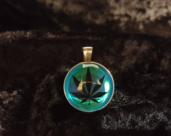 New mexico zia symbol/pot leaf glass pendant.