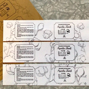 May include: White paperless towels with a floral design and the text "Reusable Multipurpose Paperless Towels". The towels are eco-friendly and designed for kitchen use. The packaging is made of brown paper.