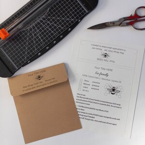 Op de afbeelding: Een set van drie bruine wasdoeken met een bijenontwerp en de tekst "Your Title Here" en "Eco-friendly". De doeken zijn gemaakt van 100% katoenen stof, bijenwas en jojoba-olie. De doeken zijn verkrijgbaar in drie maten: klein (20x20 cm), medium (30x30 cm) en groot (40x40 cm).