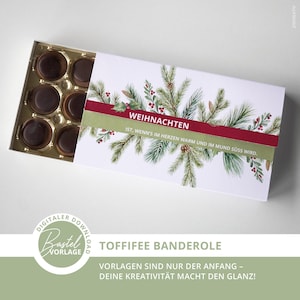 Puede incluir: Una caja de bombones Toffifee con un diseño navideño. La tapa blanca está adornada con ramas de pino verdes, bayas rojas y la palabra "WEIHNACHTEN". La caja contiene varios caramelos de caramelo cubiertos de chocolate.