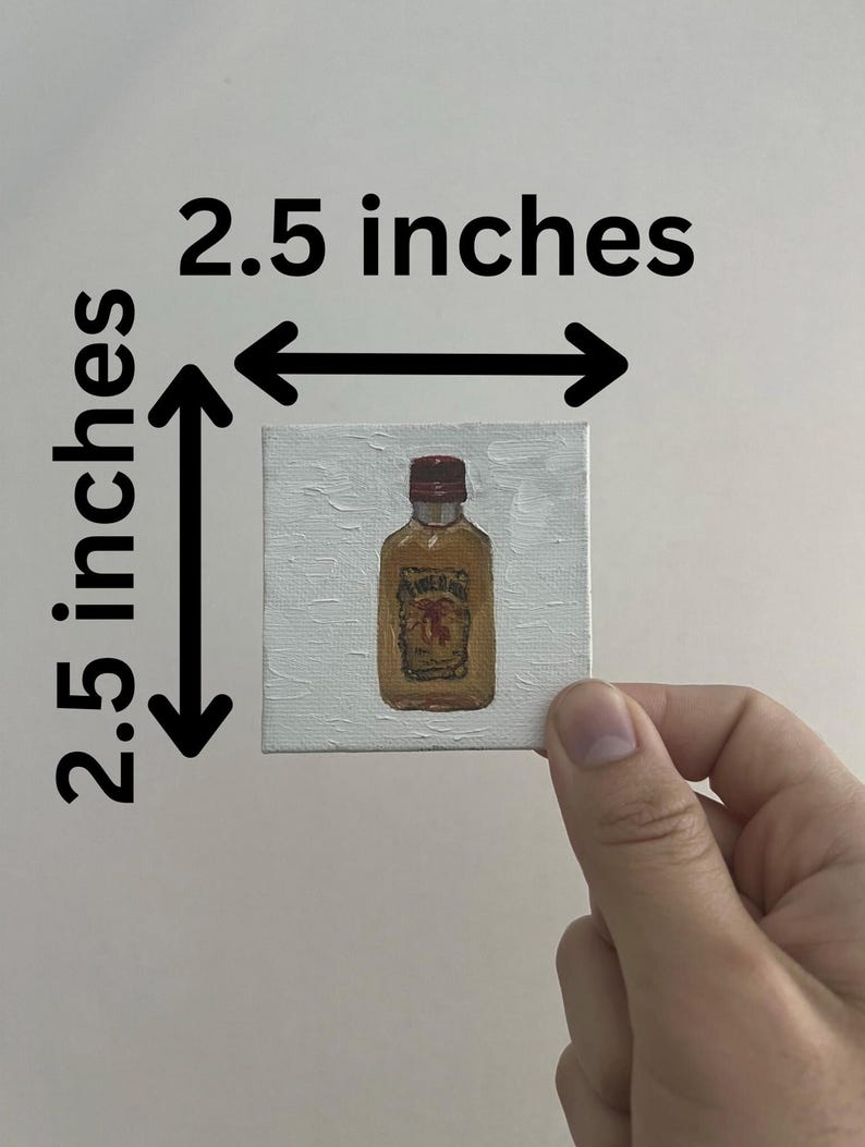 以下が含まれることがあります： 赤いキャップと茶色のラベルが付いた酒瓶の小さな正方形の絵。絵は白いキャンバスに描かれており、サイズは6.35 cm x 6.35 cmです。絵は白い背景に対して手で持たれています。