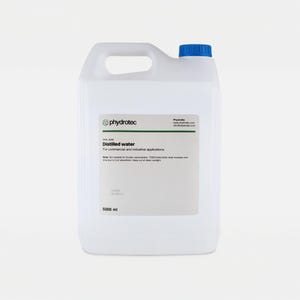 Può includere: Un contenitore di plastica bianco con un tappo blu e una maniglia. L'etichetta recita "Distilled water" e "For commercial and industrial applications." Il contenitore contiene 5000 ml di acqua distillata.