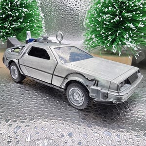 May include: A silver-colored, detailed, die-cast replica of the DeLorean time machine from the Back to the Future movie series. The car is a Christmas ornament with a loop for hanging.
