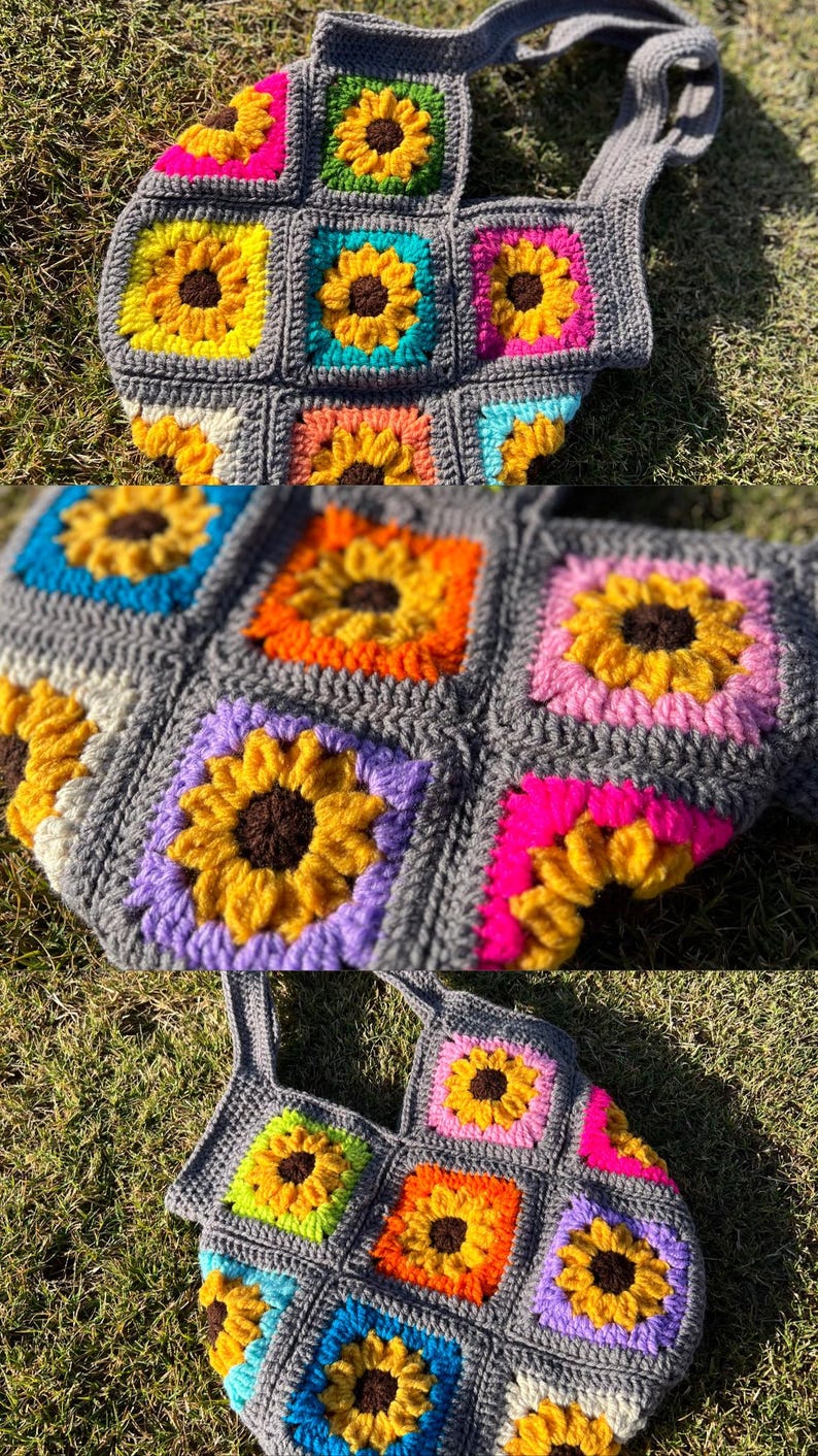 May include: A handmade crochet tote bag featuring a sunflower design. The bag is made of gray yarn with colorful squares of yellow, orange, pink, blue, and purple sunflowers. The bag has a matching gray strap.
