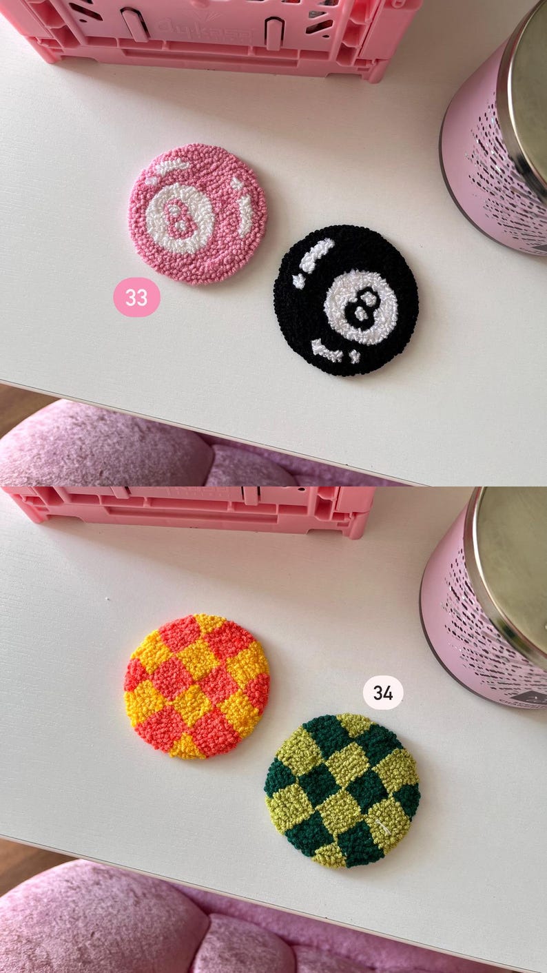 May include: Four colorful, round coasters with a textured, tufted design. One is pink with a white 8-ball design, another is black with a white 8-ball design, a third is yellow and red checkered, and the last is green and yellow checkered.